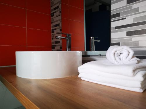 PleybenLes chambres du Bistro du Canal的浴室水槽和木制台面上的毛巾