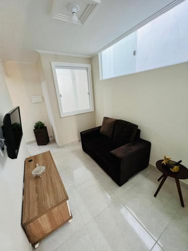 萨尔瓦多Apartamento lugar de Paz的客厅配有黑色沙发和桌子