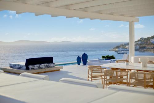 圣爱奥尼斯米科诺斯米科诺斯大酒店及度假村的一个带桌椅的庭院和大海