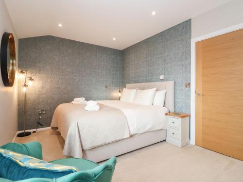 伍德布里奇Woodbridge Penthouse的卧室配有一张白色大床和一把椅子
