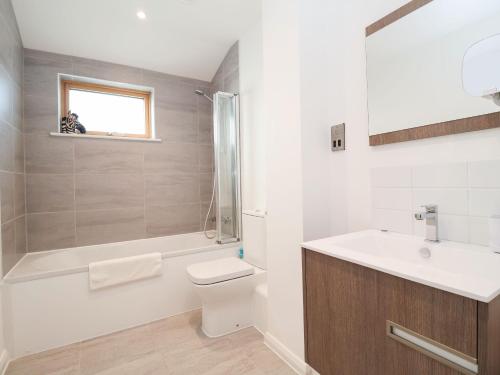 伍德布里奇Woodbridge Penthouse的浴室配有卫生间、盥洗盆和淋浴。