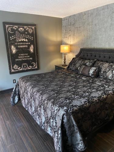 坦帕Phantom History House - Ouija Room的一间卧室配有一张大床和黑色棉被