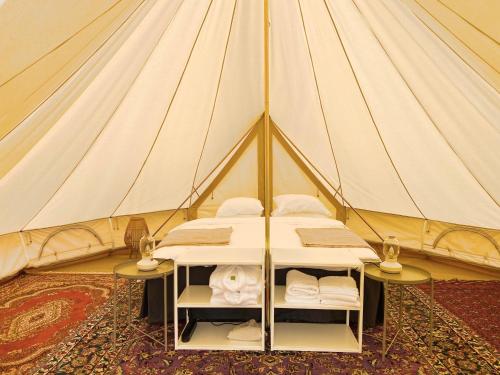斯塔德Gårdshotellets Camping的帐篷配有一张床和两张桌子