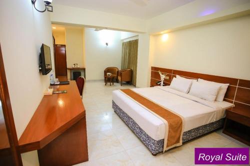 库克斯巴扎Royal Beach Resort的配有一张床和一张书桌的酒店客房