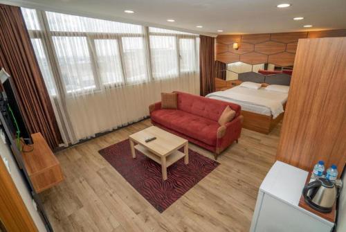 伊斯坦布尔HİLL SUİTES的客厅配有红色的沙发和床。