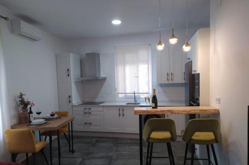 乌夫里克Loft Casa del Agua Ubrique的厨房配有白色橱柜和桌椅