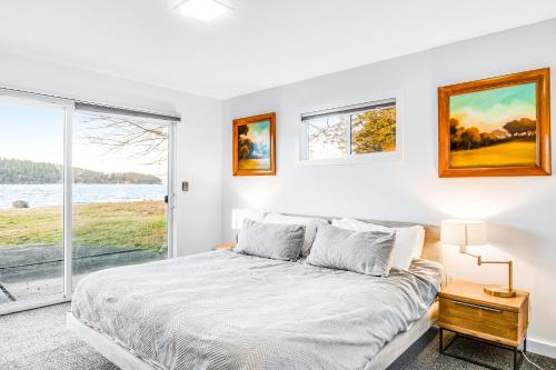 IslandaleLopez Island Mud Bay Waterfront home的白色的卧室设有床和窗户