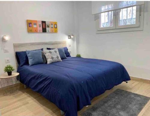 马德里Apartamento 4 personas的一间卧室,卧室内配有一张蓝色大床