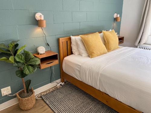 密歇根城Al & Sally's Motel的一间卧室配有一张带黄色枕头和植物的床