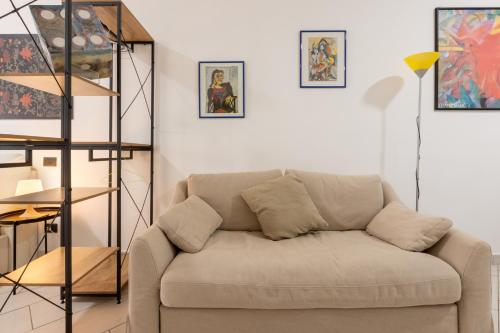 卡利亚里Locanda del buongustaio的客厅配有沙发和墙上的绘画