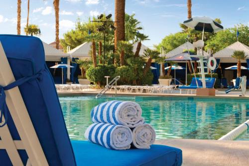 拉斯维加斯Horseshoe Las Vegas formerly Bally's的游泳池旁的蓝色椅子和滚毛巾