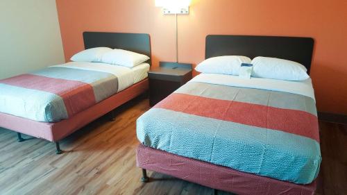 马里兰高地Motel 6-Maryland Heights, MO的配有两张床垫的酒店客房内的两张床
