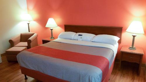 马里兰高地Motel 6-Maryland Heights, MO的酒店客房带一张大床和一把椅子