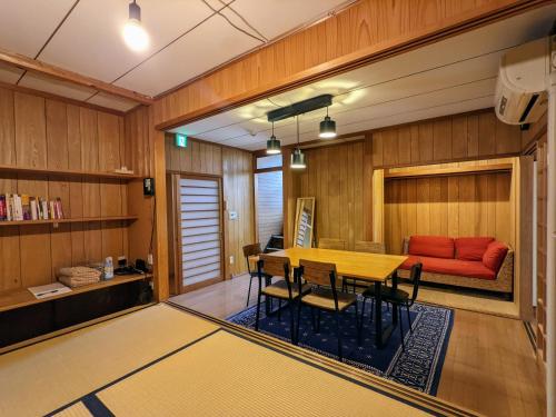奈良Yuzan apartment Sanjo的一间带桌子和红色沙发的用餐室