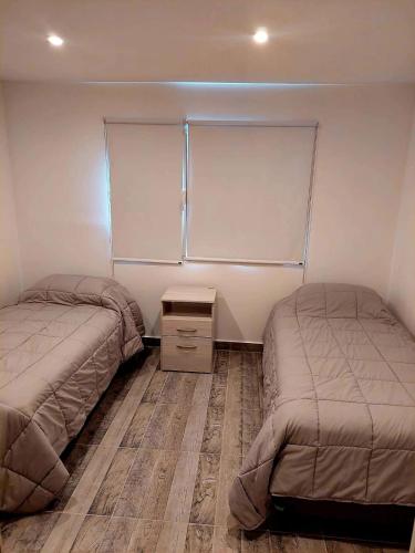 圣卡洛斯-德巴里洛切Departamento playa bonita Bariloche的一间卧室设有两张床,其中设有窗户。