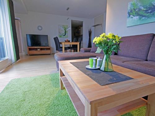 诺伊霍夫Villa Seestern - strandnah的客厅配有沙发和鲜花桌