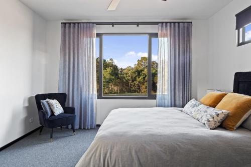 Rosa GlenRuse Estate Retreat Margaret River的卧室配有床、椅子和窗户。