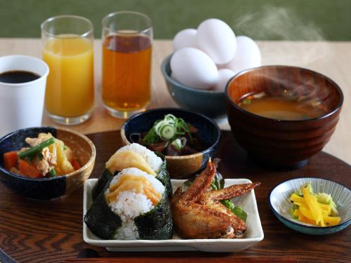 名古屋Henn na Hotel Express Nagoya Fushimi Ekimae的一张木桌,上面放着一盘食物和一些饮料