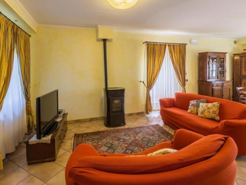 MondavioBelvilla by OYO Villa Azzurra的客厅配有橙色家具和平面电视。
