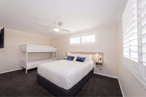 布拉德拉BIG4 River Myall Holiday Resort的卧室配有白色的床和吊扇