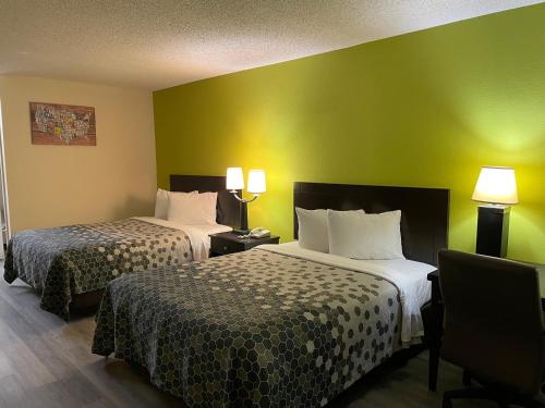 斯威特沃特Econo Lodge Inn & Suites Sweetwater I-20的绿墙旅馆客房的两张床