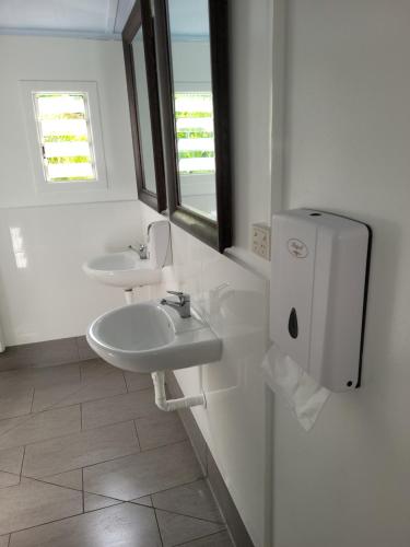 凯恩斯Travellers Paradise的白色的浴室设有两个盥洗盆和窗户。