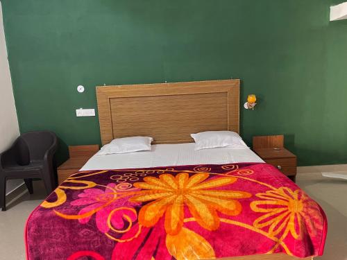 克久拉霍Hello India home stay的一间卧室配有一张大床和色彩缤纷的毯子