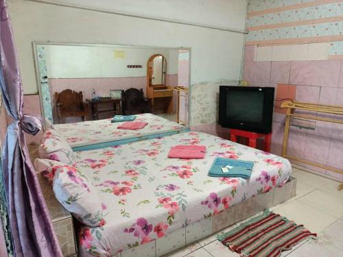 素叻坎亚纳度假酒店的一间带两张床和电视的卧室