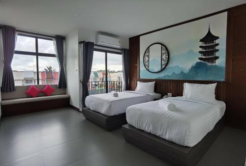 Ban Nua Khlongโรงแรมชลาลัย กระบี่ Chalalai Hotel Krabi的一间卧室设有两张床和大窗户
