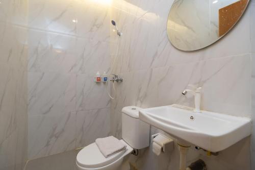茂物Sans Hotel Suryakencana Bogor的白色的浴室设有水槽和镜子