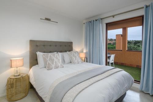 绍斯布鲁姆San Lameer Villa 2818 - 2 Bedroom Classic- 4 pax - San Lameer Rental Agency的一间卧室设有一张大床和一个大窗户