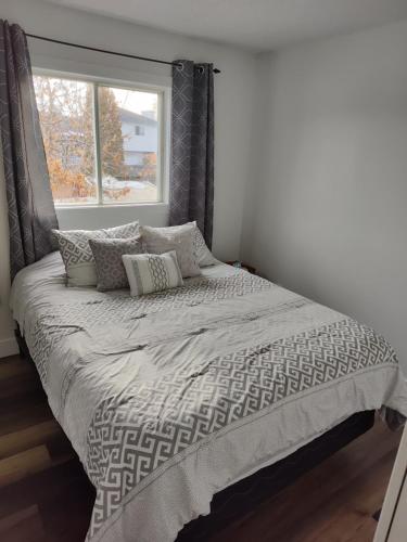 埃德蒙顿Tranquil & Tasteful One Bdrm Private Suite NE的卧室内的一张床位,带窗户