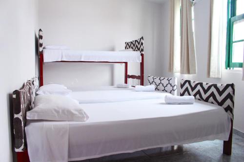 萨尔瓦多Tamboleiro's Hotel Residence的白色墙壁的客房内设有两张双层床。