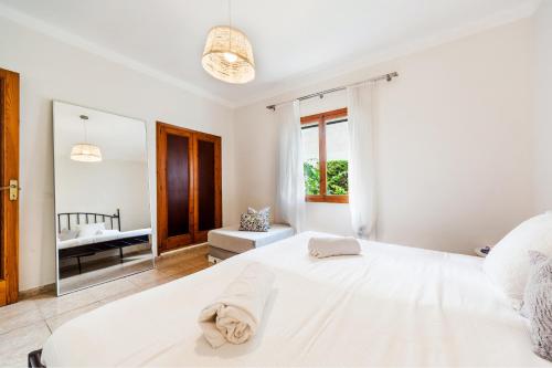 帕尔马海滩Playa de Palma Beach House的白色卧室设有一张大床和镜子