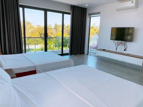 岑山Villa FLC Sầm Sơn Vị Trí Trung Tâm View Biển的酒店客房设有两张床和一台平面电视。