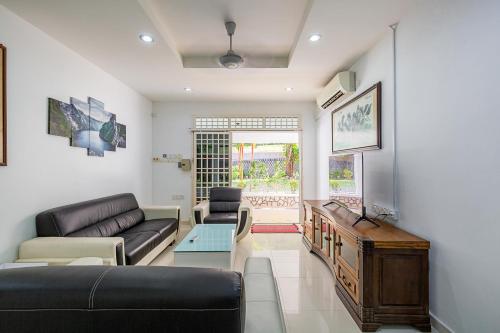 丹绒武雅Seaside Private Bungalow, Tg Bungah的客厅配有沙发和桌子