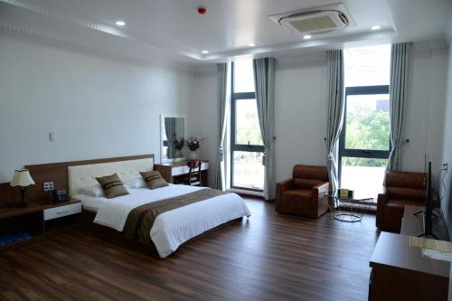 Dĩ AnHoang Hung Hotel的一间卧室配有一张床、一张桌子和一把椅子