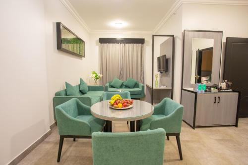 迈季迈阿Karims Hotel的一间房间,配有椅子和一张桌子,还有一碗水果