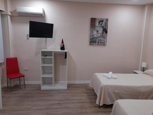 贝纳卡松Hospedaje Benacazon A49的客房设有两张床和一台平面电视。