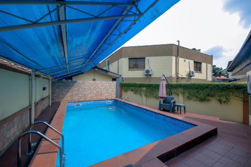 拉各斯KSF阿拉卡广场酒店的一个带蓝天篷和遮阳伞的游泳池