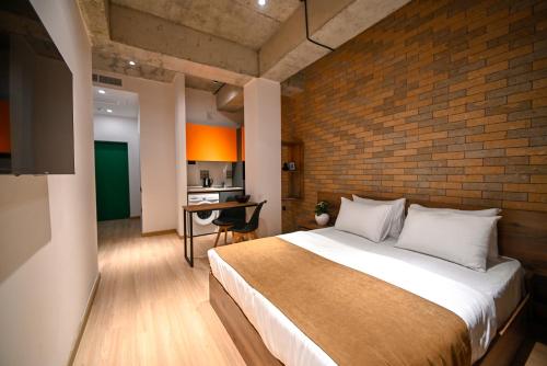 埃里温Rooms Apart-Hotel by RED的一间卧室设有一张大床和砖墙