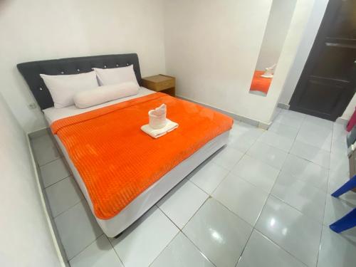 SaroakoVilla Matano Sorowako 2 Redpartner的一间卧室配有一张带橙色毯子的床