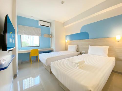 曼谷Hop Inn Bangkok Krung Thonburi Station的酒店客房配有两张床和一张书桌
