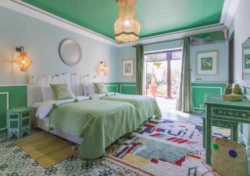 马拉喀什Maison Daouia的绿色和白色的卧室配有床和桌子