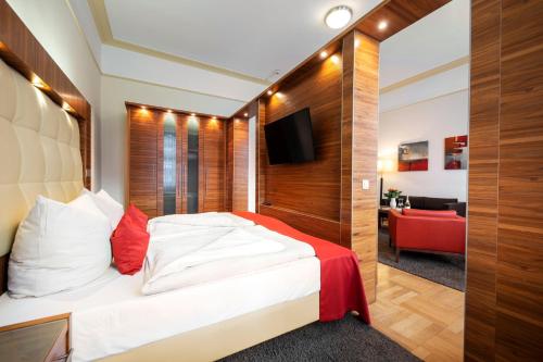 波恩ACHAT Sternhotel Bonn的一间卧室配有一张床和一张红色的沙发