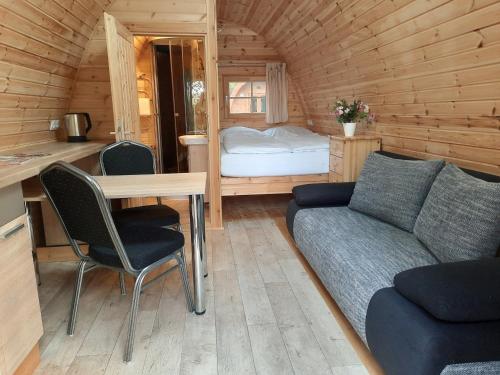 Silberstedt09 Premium Camping Pod的小屋内的客厅配有沙发和桌子