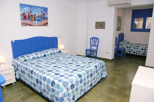 莱斯卡拉Pensió Solivent的一间卧室配有蓝色的床和两张蓝色椅子