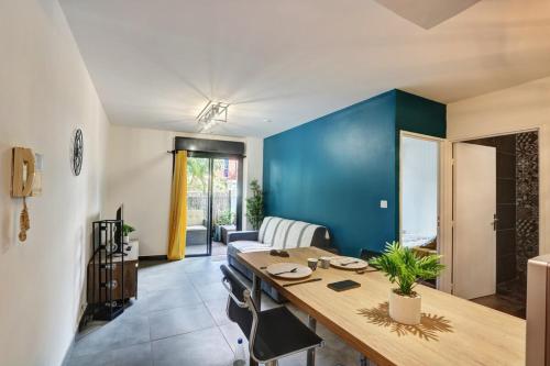 圣丹尼斯Le Zévi - appt T2 Saint Denis的一间设有桌子和蓝色墙壁的用餐室