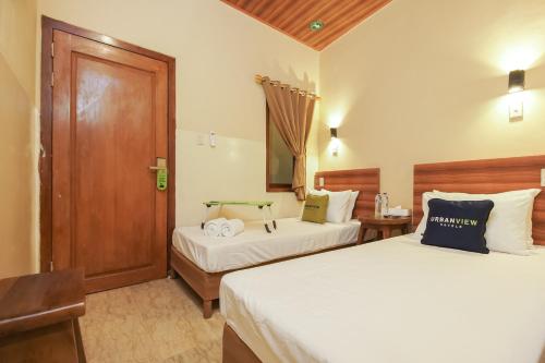 雅加达Urbanview Hotel Cantee Halim Perdanakusuma by RedDoorz的一间卧室设有两张床和木门