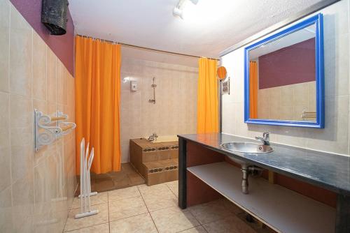 帕斯底拉卡萨Apartaments Turistics Natural Suites Manzano 3000的浴室设有橙色淋浴帘和水槽